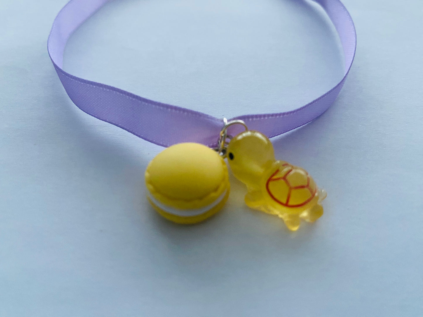 Verspielte Satinhalskette mit Macaron und Schildkröten Anhänger in lila Farben