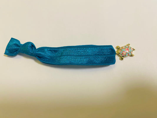 Armband aus elastischem Stoff mit einem bunten Schildkrötenanhänger